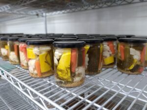 Pickle Cottage jars without labels on shelves during the canning process.