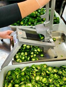 Slicing the fresh jalapeño peppers by hand